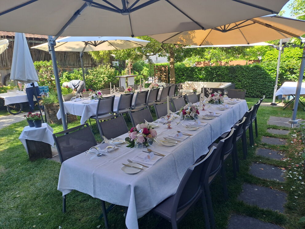 Festively laid table in the garden with flowers and parasols