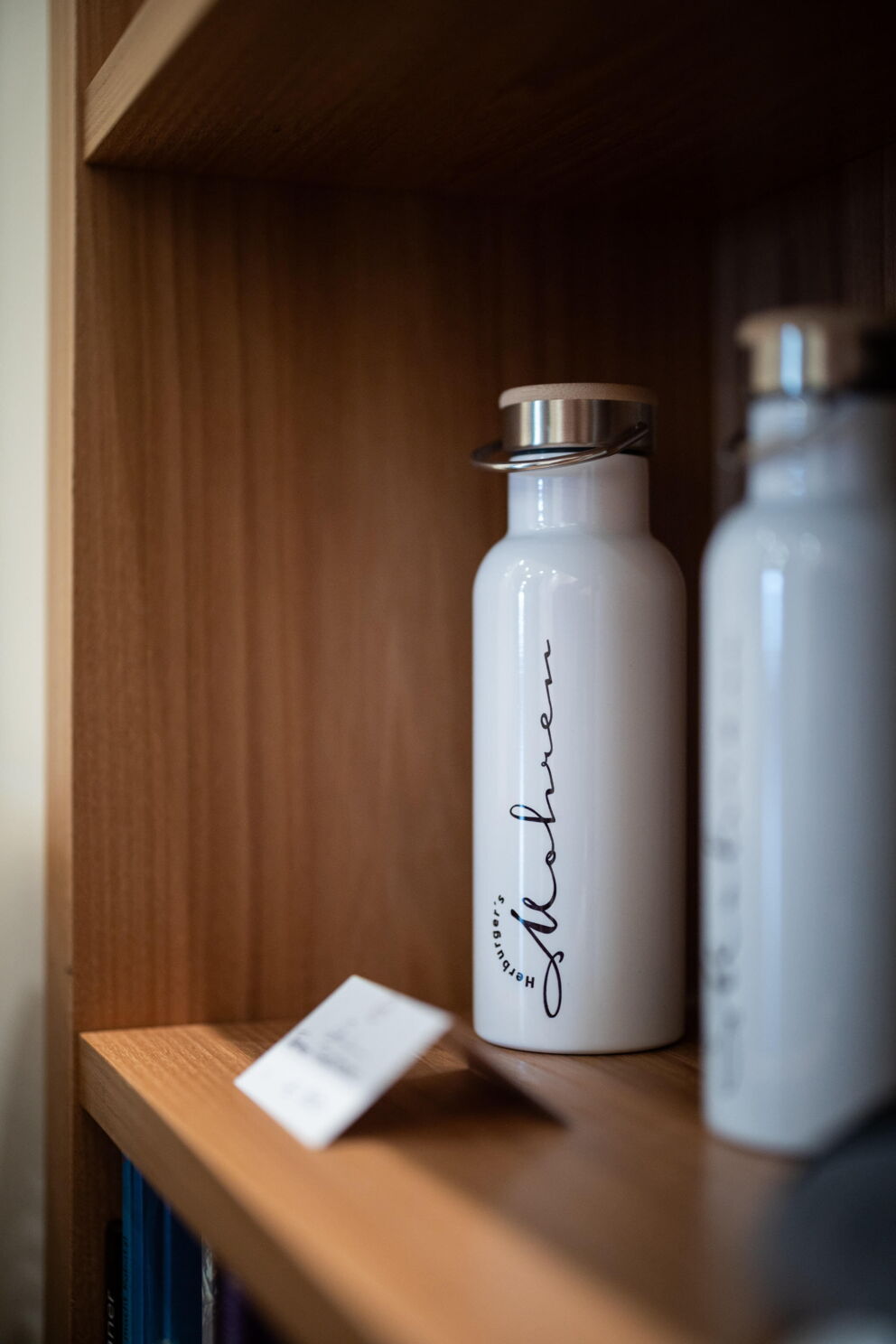 Weiße Flasche mit Mohren-Logo auf einem Holzregal, modernes Design.
