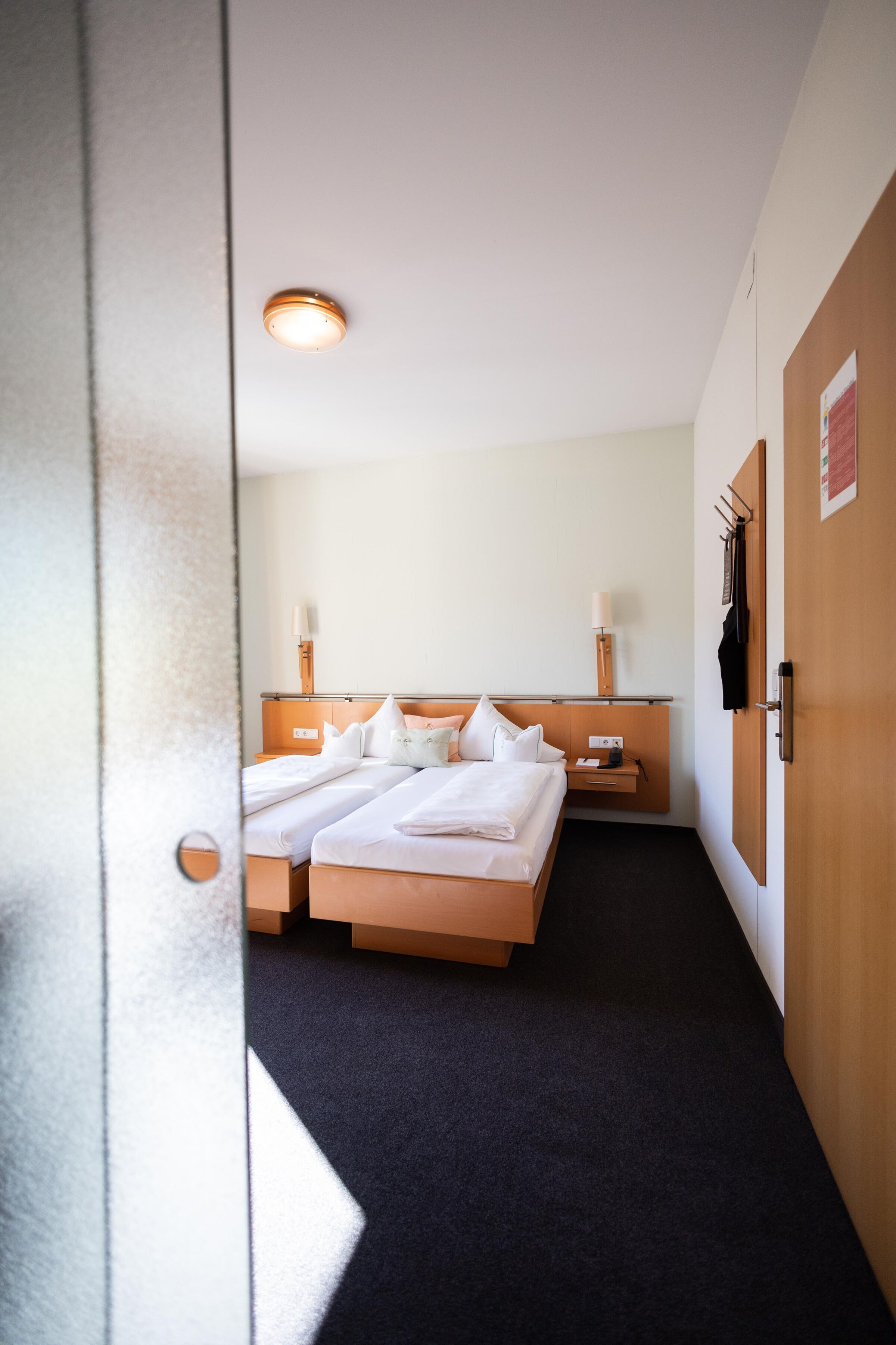 Bright room with two beds, wooden furniture and soft bed linen.