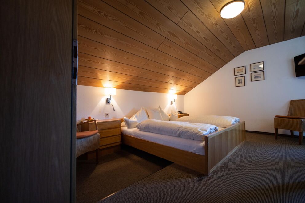 Gemütliches Zimmer mit Holzakzenten und sanfter Beleuchtung für pure Entspannung.