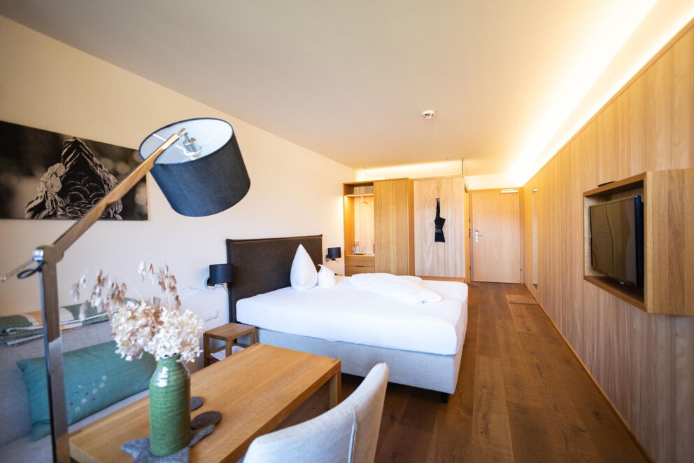 Stilvolles Zimmer mit Holzmöbeln, gemütlicher Beleuchtung und moderner Dekoration.