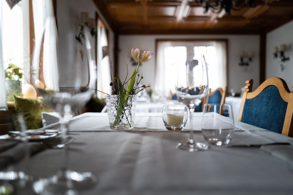 Elegant gedeckter Tisch mit zartem Blumenschmuck und stilvollen Weingläsern.