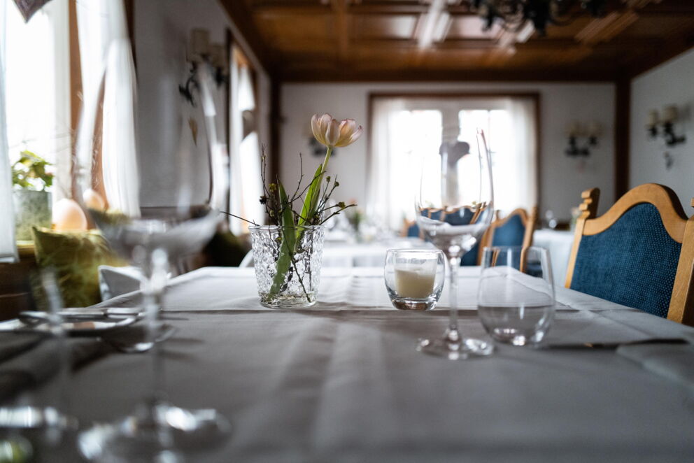 Elegantly laid table with delicate floral decorations and stylish wine glasses.