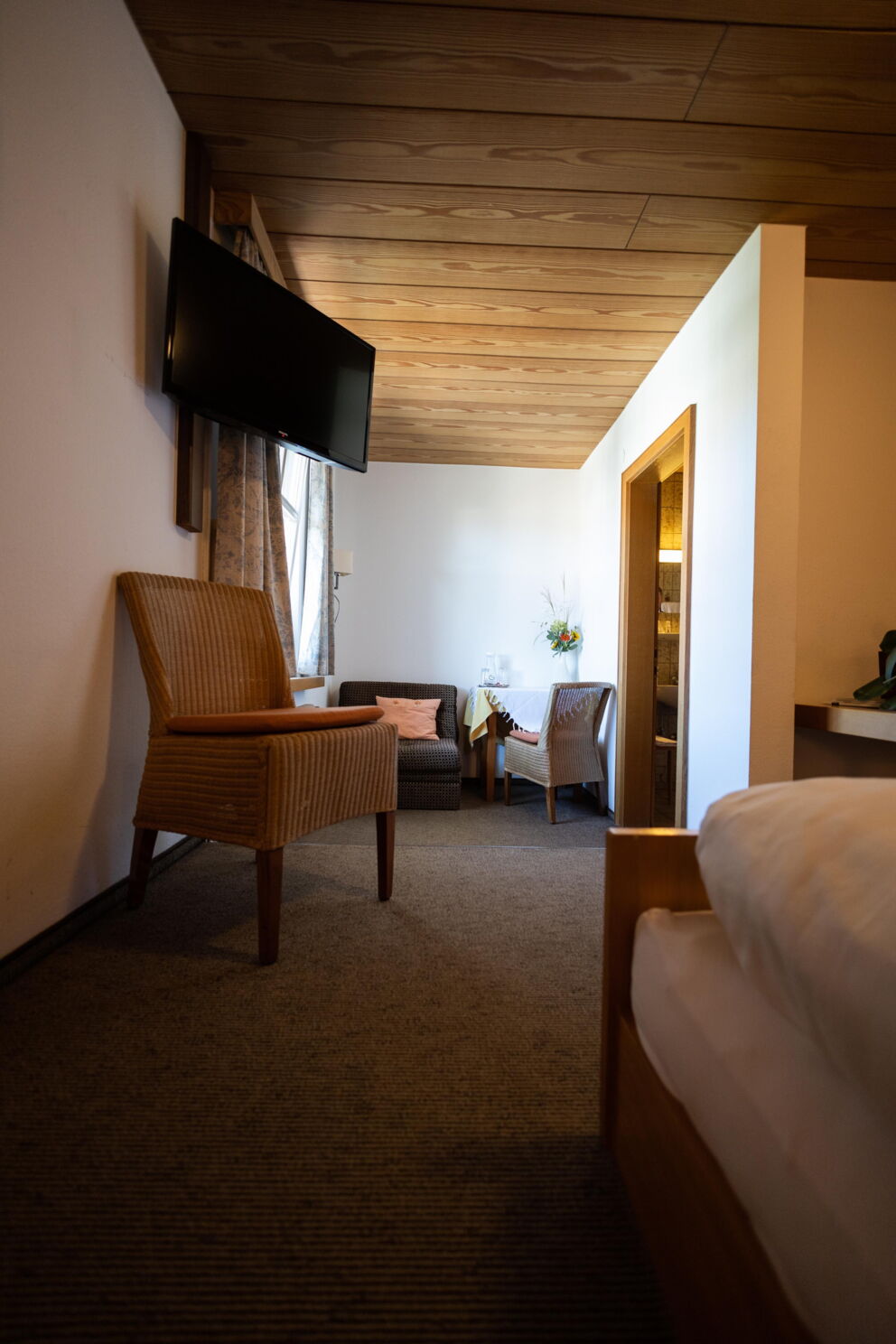 Komfortable Sitzecke mit Holzmöbeln und sanfter Beleuchtung in einem Gästezimmer.