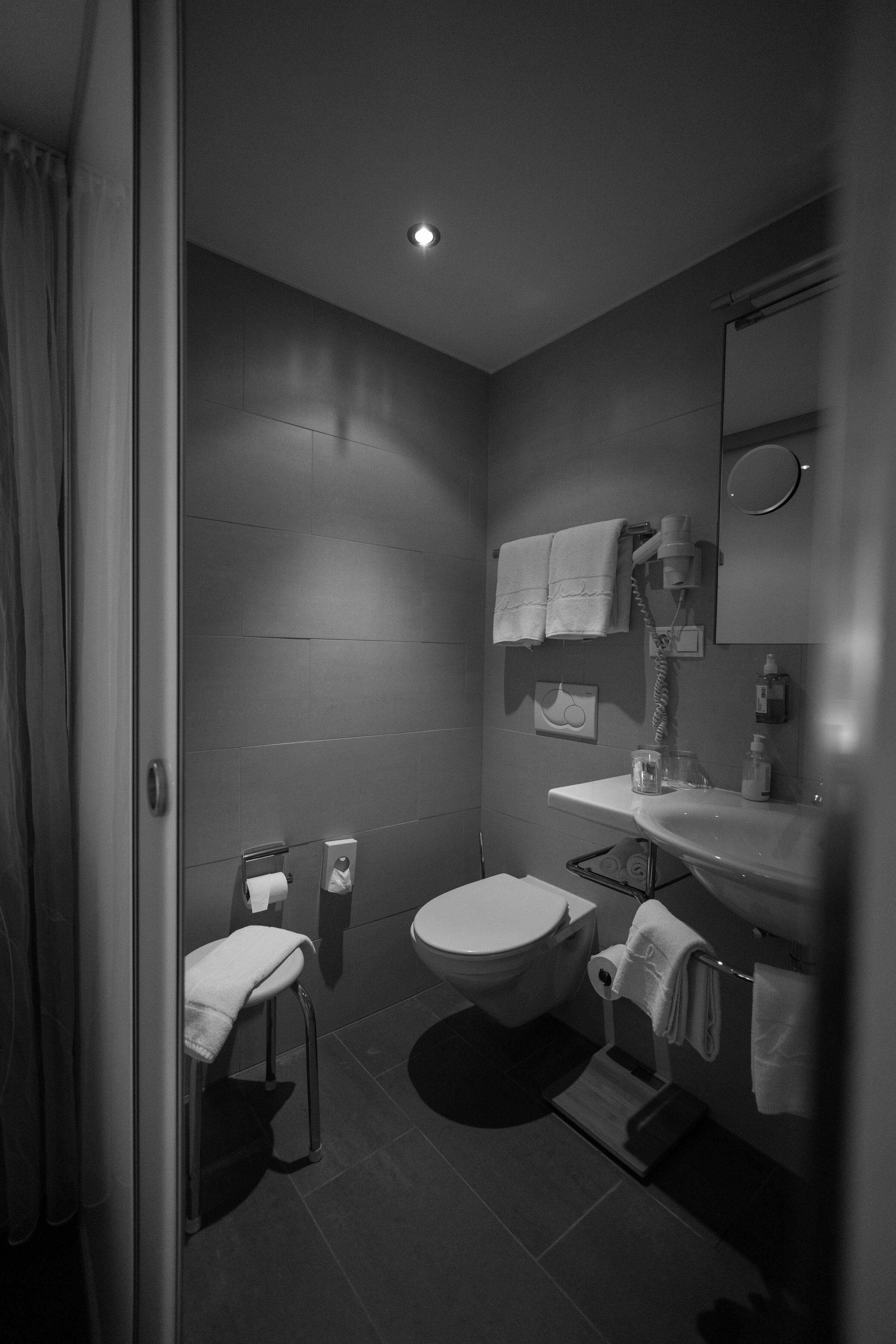 Elegant bathroom with towels, WC, washbasin and discreet lighting.