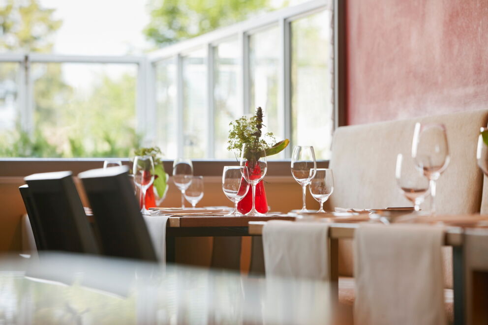 Bright restaurant with table settings, fresh flowers and soft daylight
