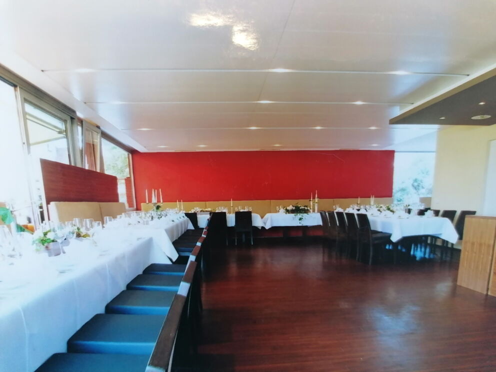 Stylishly decorated banquet hall with white tablecloths and modern chairs.