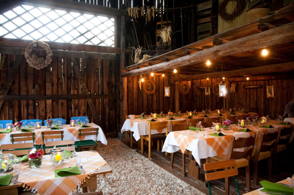 Comfortably laid tables in a rustic wooden interior with warm lighting.