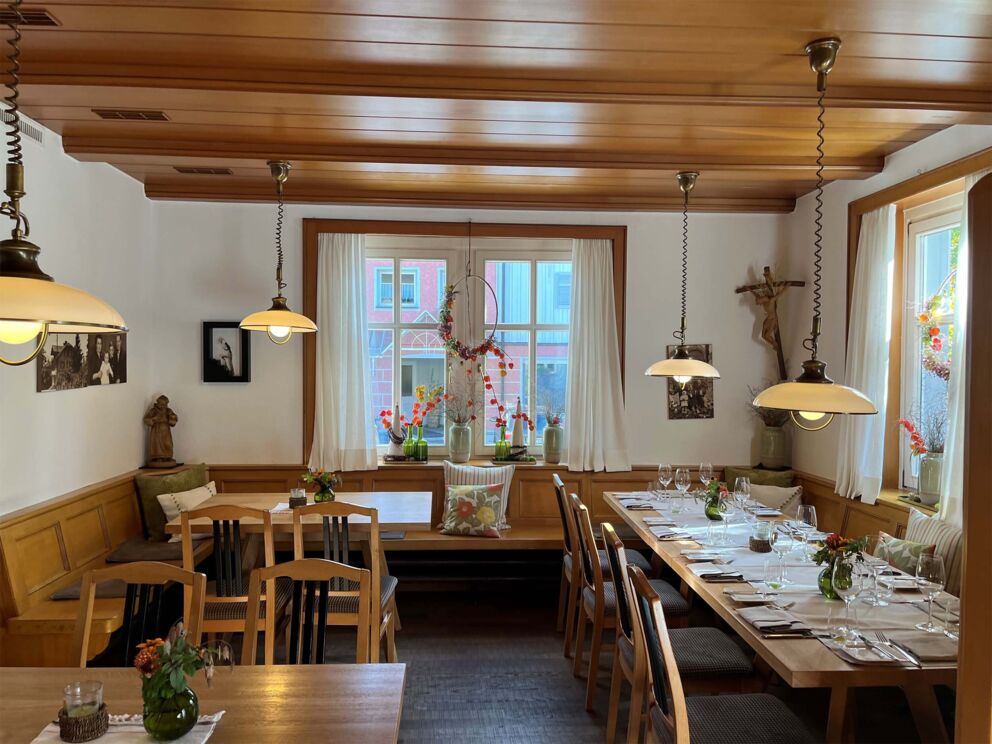 Cozy dining room with wooden furniture, table setting and soft lighting.