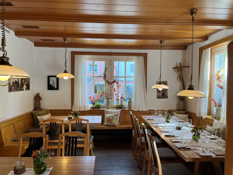 Cozy dining room with wooden furniture, table setting and soft lighting.