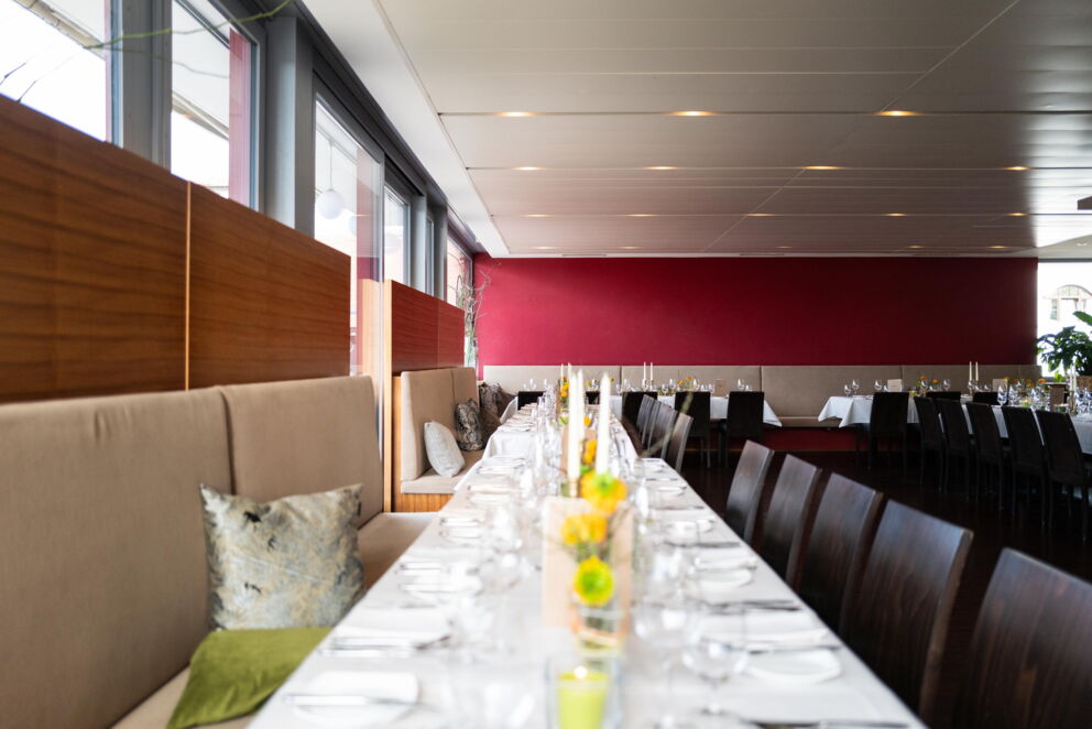 Stylishly laid long table with flower arrangements and red accent walls.