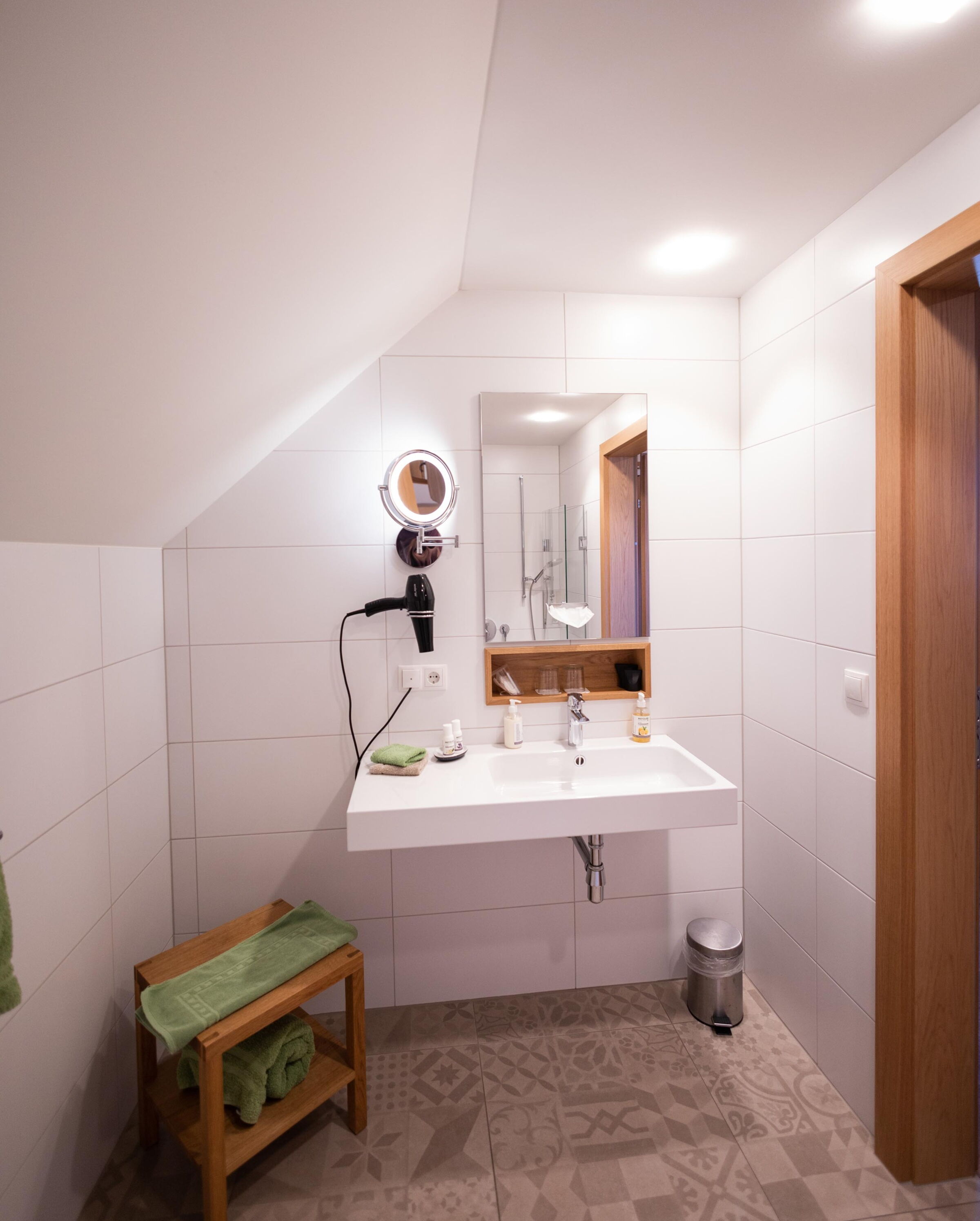 Modern bathroom with stylish tiles, washbasin and mirror lighting.